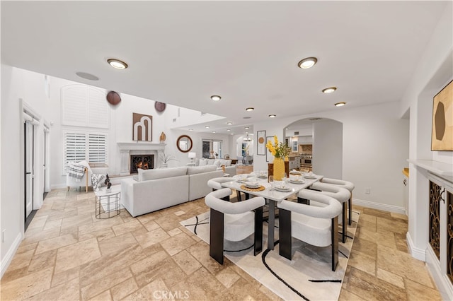 25811 Jamon Ln, Mission Viejo, CA 92691 - dining room with stone tile flooring, a warm lit fireplace, arched walkways, and recessed lighting
