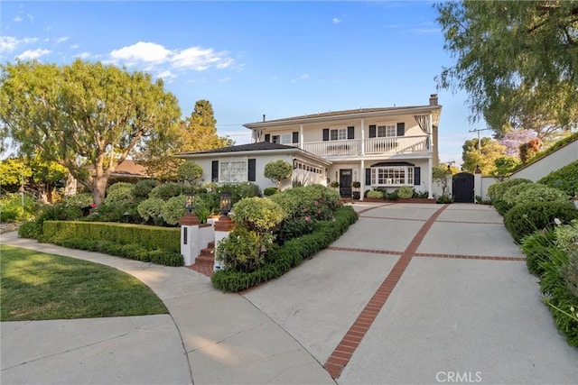 2136 W Gaucho Dr, Rancho Palos Verdes, CA 90275 - traditional home with a balcony, a gate, concrete driveway, a chimney, and a garage