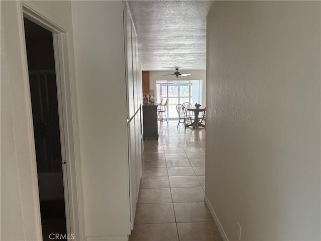 2770 Cole Ave, Highland, CA 92346 - hall with a textured ceiling, light tile patterned floors, a textured wall, and baseboards