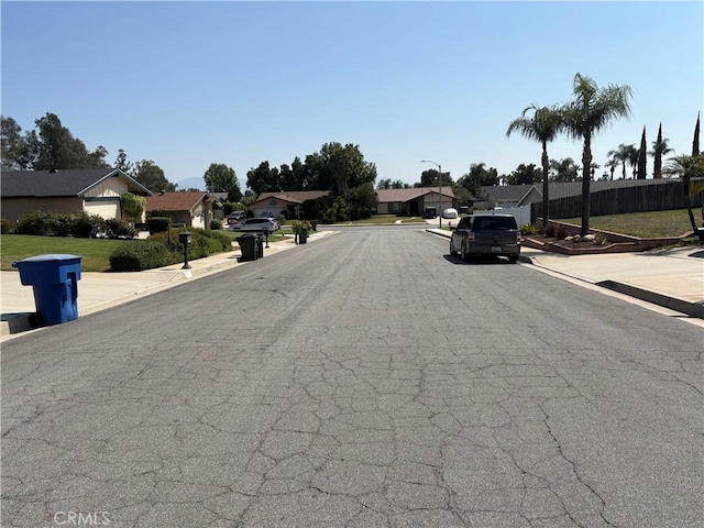 2770 Cole Ave, Highland, CA 92346 - view of asphalt road featuring curbs, street lighting, a residential view, and sidewalks