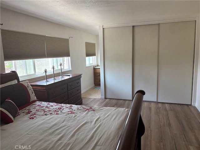 2770 Cole Ave, Highland, CA 92346 - bedroom featuring light wood-style floors, a closet, a textured ceiling, and baseboards