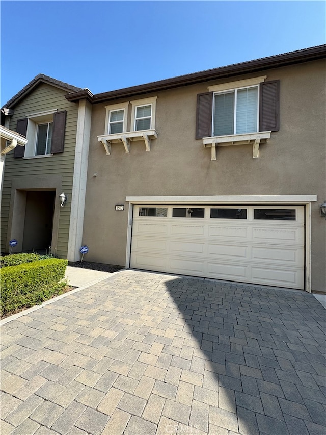 1502 Beacon, Upland, CA 91786 - view of front facade featuring decorative driveway, an attached garage, and stucco siding