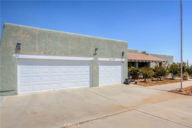 8140 Del Ct, Phelan, CA 92371 - view of front of home with concrete driveway, stucco siding, and an attached garage