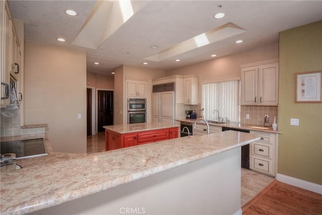 8140 Del Ct, Phelan, CA 92371 - kitchen with a skylight, double oven, backsplash, recessed lighting, and light stone countertops