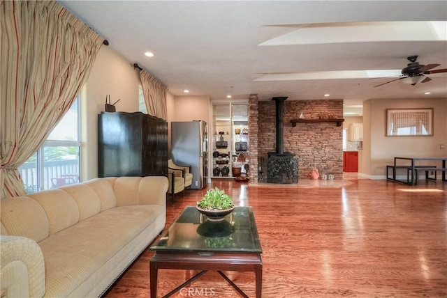 8140 Del Ct, Phelan, CA 92371 - living area featuring a wood stove, wood finished floors, a ceiling fan, baseboards, and recessed lighting