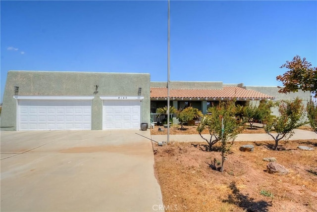 8140 Del Ct, Phelan, CA 92371 - southwest-style home featuring driveway, stucco siding, and an attached garage