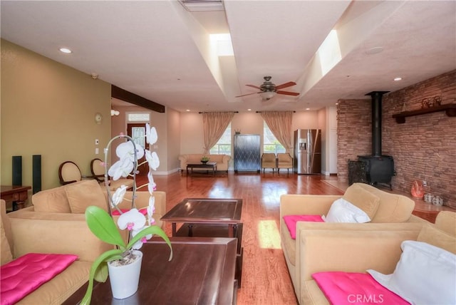 8140 Del Ct, Phelan, CA 92371 - living room with a ceiling fan, wood finished floors, a wood stove, and baseboards