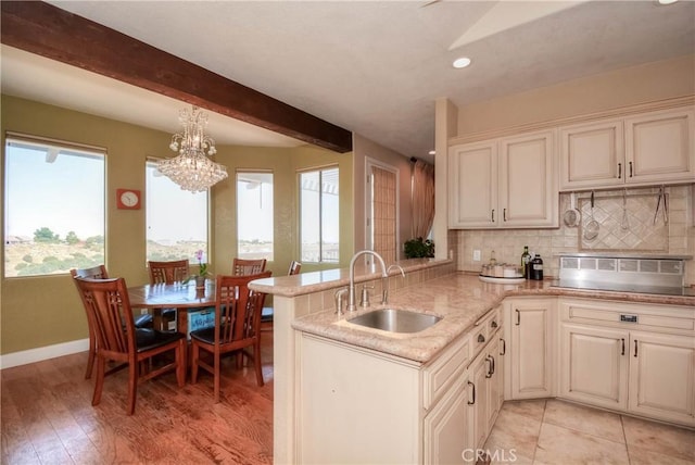 8140 Del Ct, Phelan, CA 92371 - kitchen with a sink, tasteful backsplash, a chandelier, light stone countertops, and a peninsula