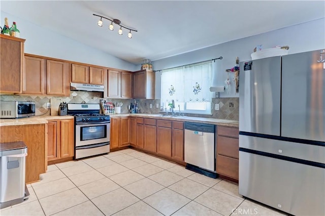 12642 Gorham St, Moreno Valley, CA 92553 - kitchen featuring appliances with stainless steel finishes, under cabinet range hood, light countertops, light tile patterned floors, and decorative backsplash