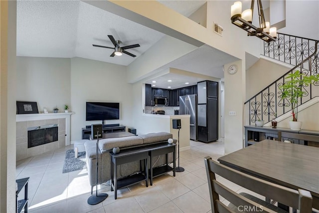 1844 W Falmouth Ave Unit 5, Anaheim, CA 92801 - living area with light tile patterned floors, stairs, ceiling fan, a chandelier, and a tiled fireplace