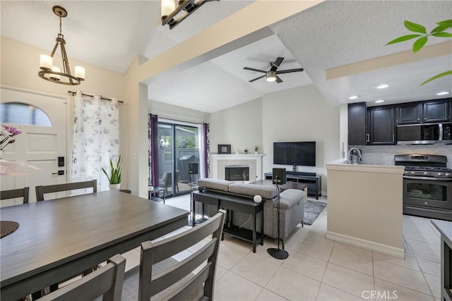 1844 W Falmouth Ave Unit 5, Anaheim, CA 92801 - living room featuring lofted ceiling, light tile patterned flooring, a ceiling fan, a textured ceiling, and a chandelier
