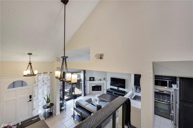 1844 W Falmouth Ave Unit 5, Anaheim, CA 92801 - living area featuring light tile patterned flooring, a chandelier, vaulted ceiling, and a fireplace