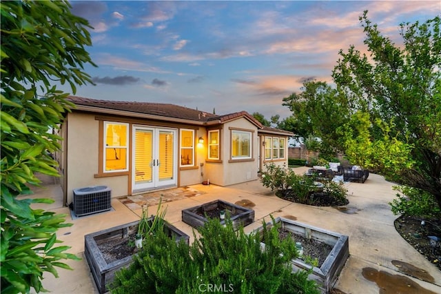 20010 Livorno Ln, Yorba Linda, CA 92886 - back of property at dusk with a fire pit, french doors, a patio area, cooling unit, and stucco siding