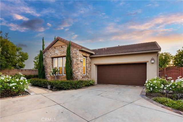 20010 Livorno Ln, Yorba Linda, CA 92886 - view of front of house with driveway, stone siding, an attached garage, and stucco siding
