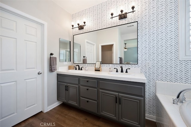 28978 Williston Ct, Temecula, CA 92591 - bathroom featuring double vanity, a garden tub, ceiling fan, tasteful backsplash, and wood finished floors