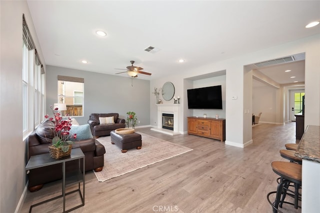 28978 Williston Ct, Temecula, CA 92591 - living area featuring light wood-type flooring, ceiling fan, a glass covered fireplace, and recessed lighting