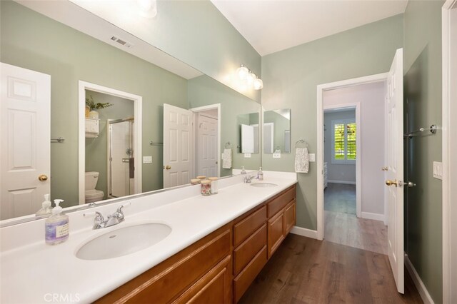 28978 Williston Ct, Temecula, CA 92591 - bathroom featuring wood finished floors, double vanity, and a shower stall
