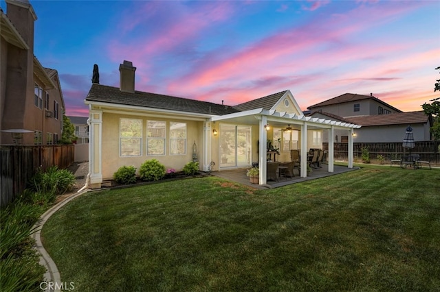 28978 Williston Ct, Temecula, CA 92591 - back of house at dusk with a chimney, a fenced backyard, a patio area, ceiling fan, and stucco siding