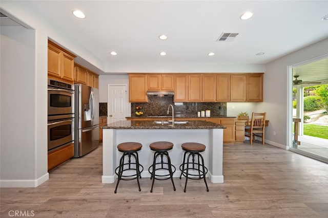 28978 Williston Ct, Temecula, CA 92591 - kitchen featuring stainless steel appliances, under cabinet range hood, backsplash, recessed lighting, and a center island with sink
