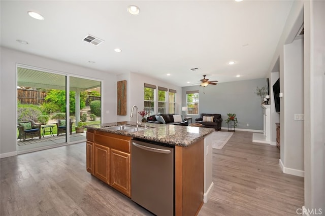 28978 Williston Ct, Temecula, CA 92591 - kitchen featuring stainless steel dishwasher, a center island with sink, light stone countertops, open floor plan, and light wood-type flooring