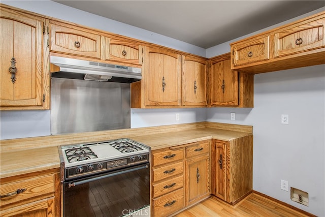 6429 Cedar Ave, Angelus Oaks, CA 92305 - kitchen featuring gas range oven, under cabinet range hood, light countertops, light wood-style floors, and brown cabinetry