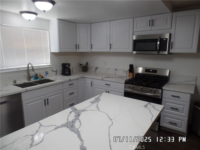 1676 Dumbarton Ave, San Bernardino, CA 92404 - kitchen with appliances with stainless steel finishes, white cabinets, and light stone counters