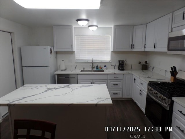 1676 Dumbarton Ave, San Bernardino, CA 92404 - kitchen featuring appliances with stainless steel finishes, dark wood-type flooring, white cabinetry, and light stone counters