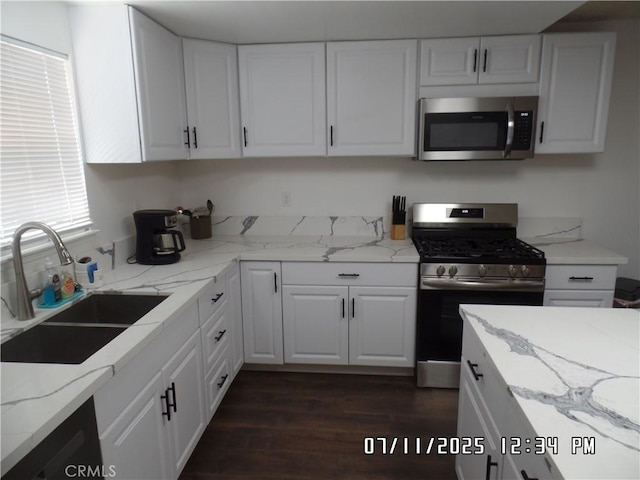 1676 Dumbarton Ave, San Bernardino, CA 92404 - kitchen featuring appliances with stainless steel finishes, white cabinetry, dark wood-style floors, and light stone countertops