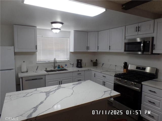 1676 Dumbarton Ave, San Bernardino, CA 92404 - kitchen with appliances with stainless steel finishes, white cabinetry, and light stone countertops
