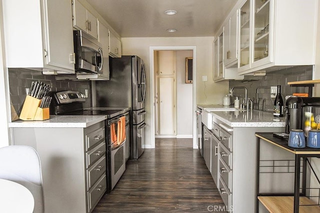 188 Temple Ave Unit 201, Long Beach, CA 90803 - kitchen with stainless steel appliances, gray cabinetry, dark wood-style flooring, backsplash, and glass insert cabinets