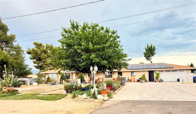 15994 Cactus St, Hesperia, CA 92345 - view of front of home featuring solar panels, an attached garage, and driveway