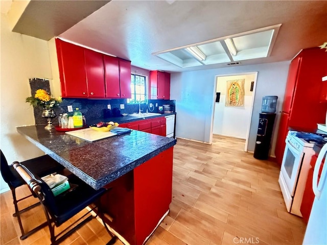 15994 Cactus St, Hesperia, CA 92345 - kitchen with red cabinets, white appliances, backsplash, a sink, and a peninsula