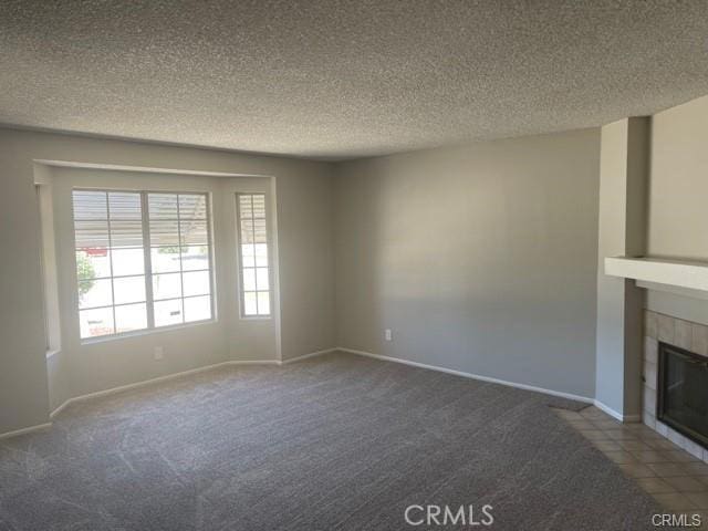 900 Raquel Ct, Hemet, CA 92545 - unfurnished living room featuring a textured ceiling, a tile fireplace, carpet, and baseboards