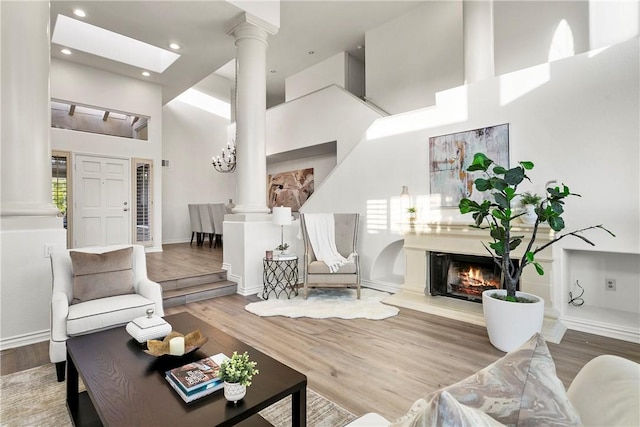 11 Porto Cervo Dr, Dana Point, CA 92629 - living area with decorative columns, wood finished floors, a towering ceiling, a glass covered fireplace, and recessed lighting