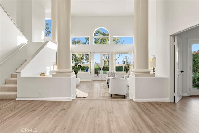 11 Porto Cervo Dr, Dana Point, CA 92629 - unfurnished living room with ornate columns, a high ceiling, wood finished floors, and stairway