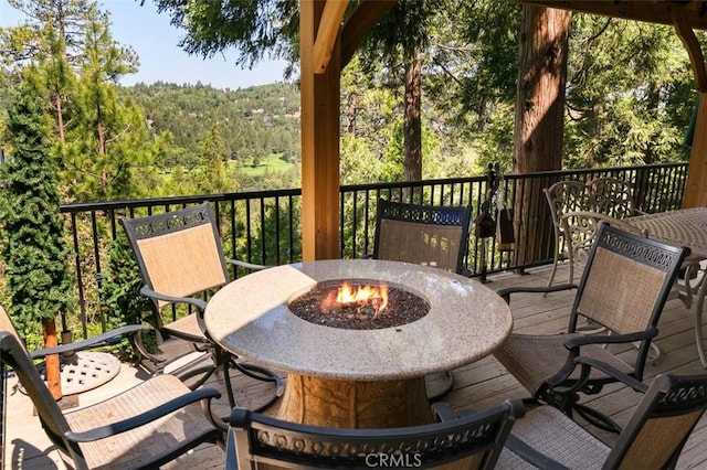 430 Rainier Rd, Lake Arrowhead, CA 92352 - wooden deck featuring a fire pit and a forest view