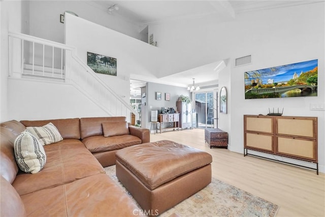 2940 Cherry Way, Ontario, CA 91761 - living area with ornamental molding, stairway, light wood finished floors, a chandelier, and a high ceiling