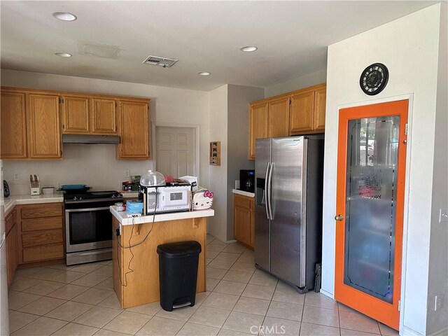 1538 Regents St, Lancaster, CA 93534 - kitchen featuring appliances with stainless steel finishes, under cabinet range hood, light countertops, a center island, and light tile patterned floors