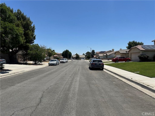 1538 Regents St, Lancaster, CA 93534 - view of asphalt street featuring a residential view, sidewalks, curbs, and street lights