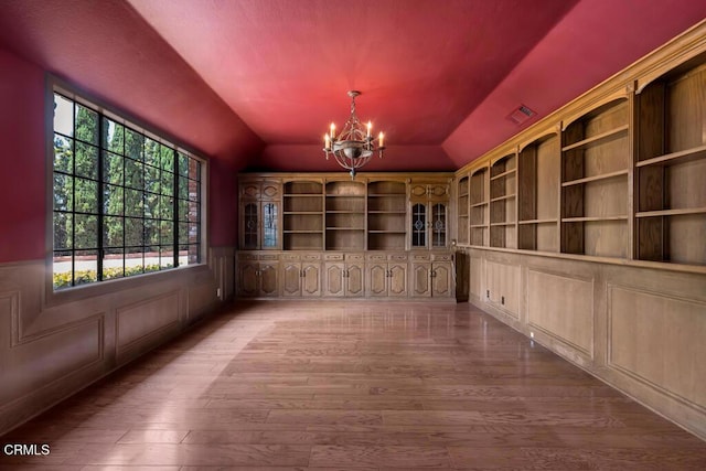 11395 Highridge Ct, Camarillo, CA 93012 - unfurnished dining area featuring lofted ceiling, a chandelier, wood finished floors, and wainscoting