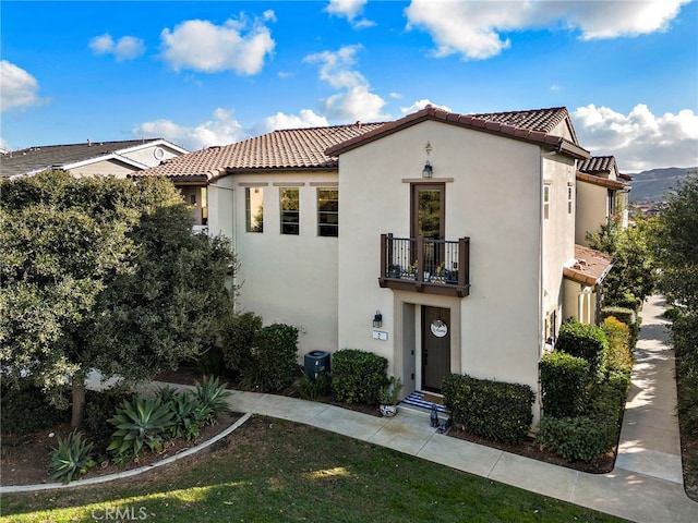 2 Jaripol Cir, Rancho Mission Viejo, CA 92694 - mediterranean / spanish-style house featuring a balcony, a tiled roof, stucco siding, and a front lawn