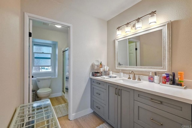 1651 S Juniper St Unit 106, Escondido, CA 92025 - full bathroom featuring toilet, vanity, a stall shower, wood finished floors, and baseboards