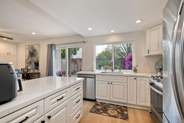 1651 S Juniper St Unit 106, Escondido, CA 92025 - kitchen with stainless steel appliances, a sink, light wood-type flooring, recessed lighting, and white cabinets