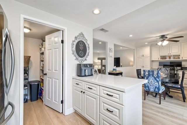 1651 S Juniper St Unit 106, Escondido, CA 92025 - kitchen with freestanding refrigerator, light wood-type flooring, white cabinetry, a ceiling fan, and light countertops