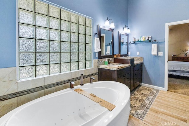 3475 Paseo Verde Ave, Merced, CA 95348 - ensuite bathroom with a jetted tub, wood finished floors, vanity, and baseboards