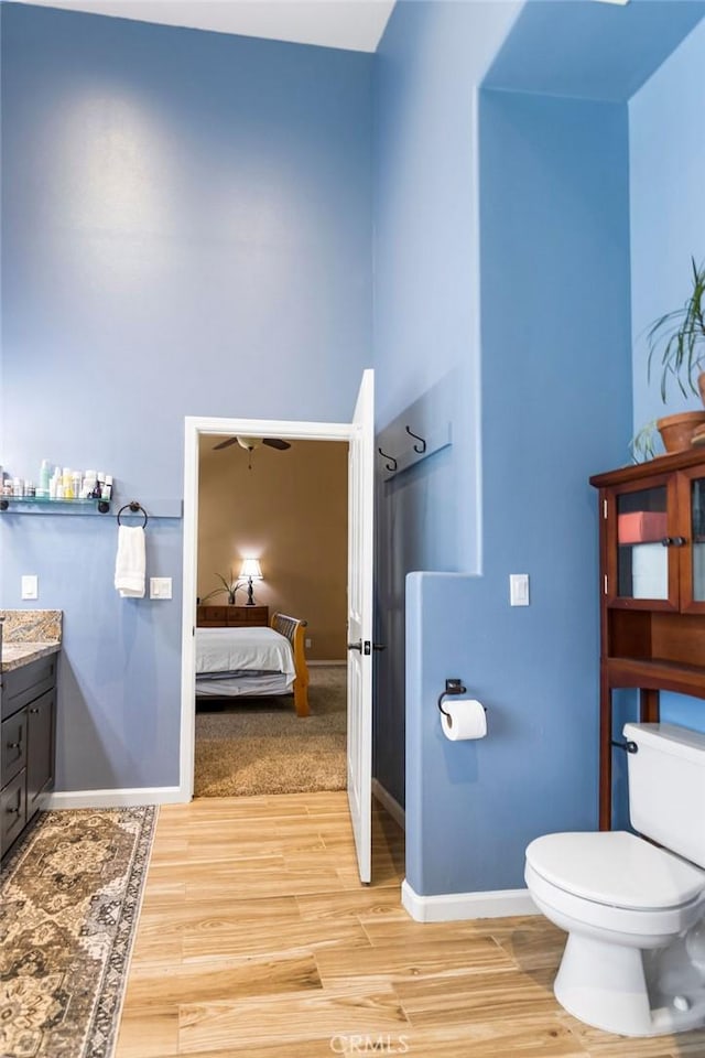3475 Paseo Verde Ave, Merced, CA 95348 - ensuite bathroom with vanity, toilet, wood finished floors, and baseboards