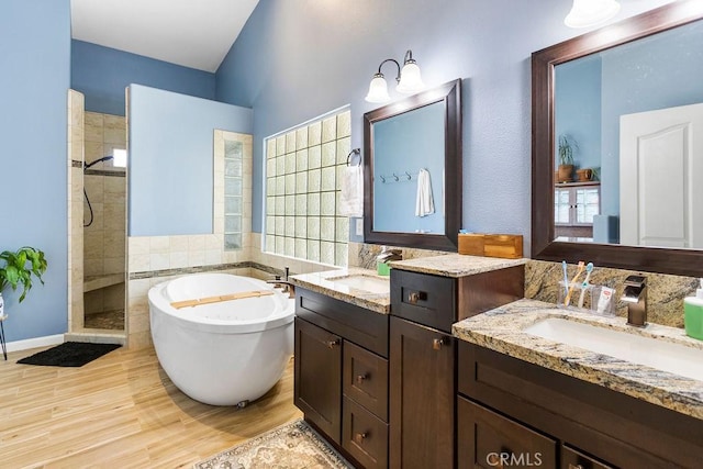 3475 Paseo Verde Ave, Merced, CA 95348 - bathroom featuring tiled shower, a freestanding tub, two vanities, and wood finished floors