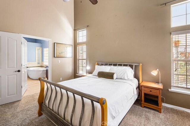 3475 Paseo Verde Ave, Merced, CA 95348 - bedroom featuring a towering ceiling, multiple windows, light colored carpet, and connected bathroom