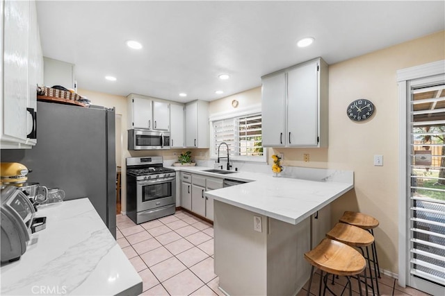 37398 Harrow Ct, Palmdale, CA 93550 - kitchen with appliances with stainless steel finishes, a peninsula, healthy amount of natural light, a breakfast bar area, and recessed lighting