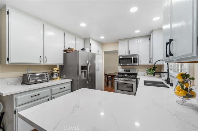 37398 Harrow Ct, Palmdale, CA 93550 - kitchen featuring appliances with stainless steel finishes, recessed lighting, light stone counters, and white cabinetry